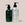 Two Acure Organics bottles, one green and one silver, on a light beige background.